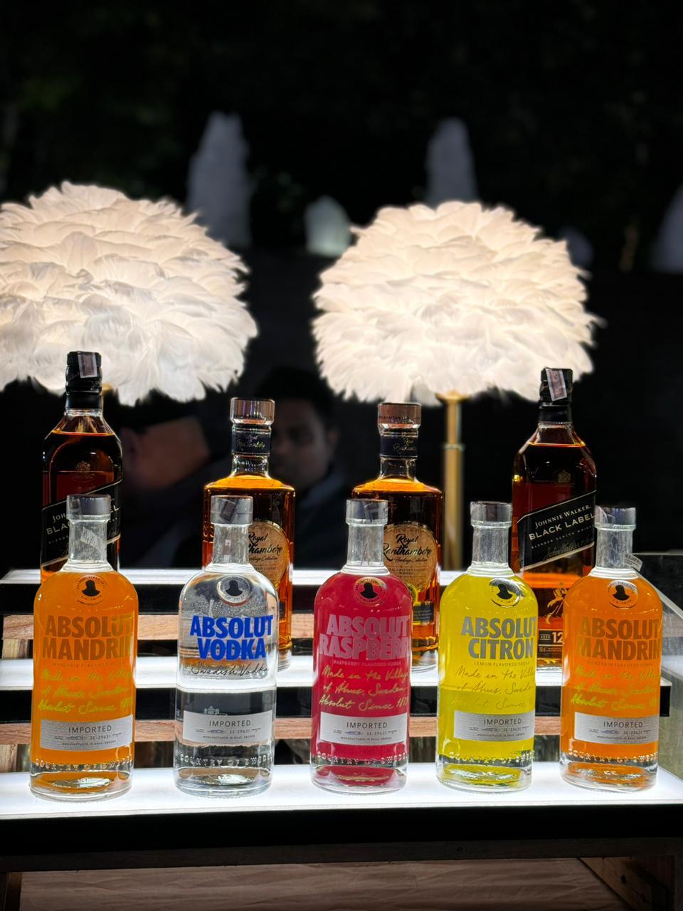 Elegant bar setup with a variety of drinks and glassware, perfect for any event.