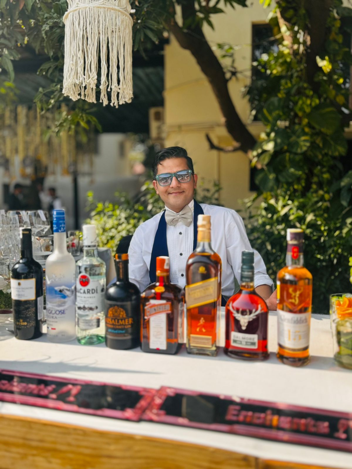 Bartender serving guests at a lively event with a beautifully decorated bar