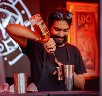 Mohit, lead mixologist at Drinks by Mo, expertly pours premium whiskey into a glass at an exclusive event in Chennai.
