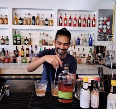 Mohit, chief mixologist at Drinks by Mo, skillfully stirs a signature cocktail creation, infusing flavors with precision and style.